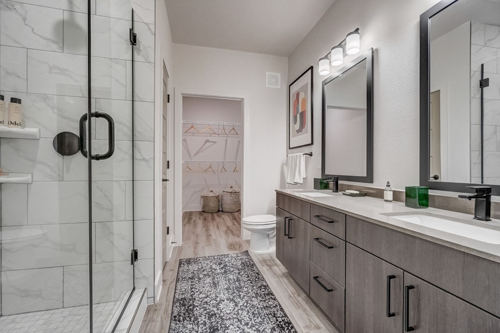 a bathroom with a shower and a sink and a mirror