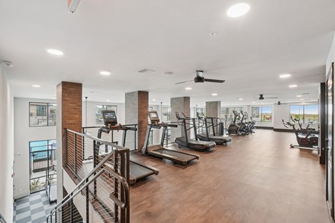A gym with treadmills, elliptical machines, and other exercise equipment.