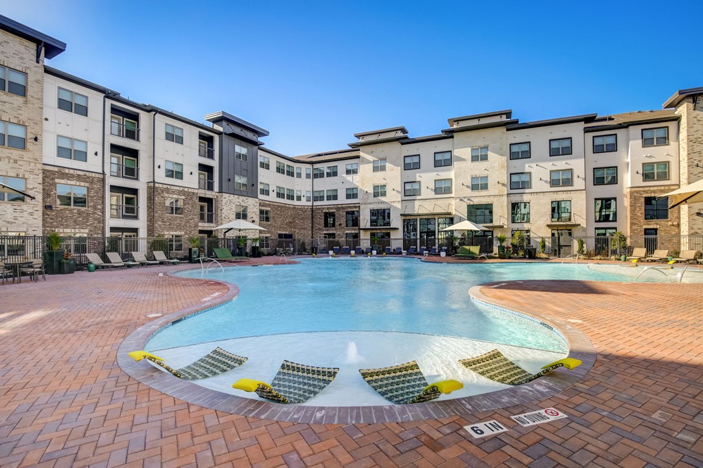 a large swimming pool in front of an apartment building