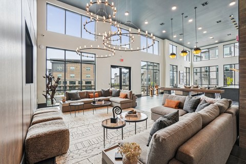 A modern living room with a large couch and a chandelier.