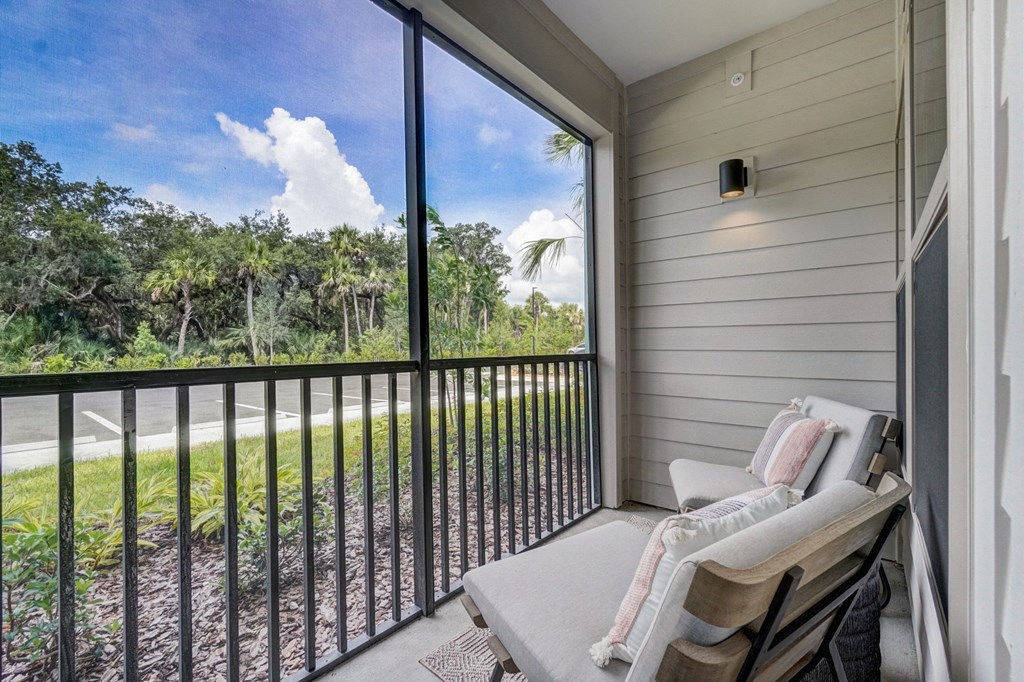 a balcony with a couch and a chair and a window