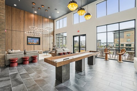 A large wooden table is in the middle of a room with a long bench and a painting on the wall.