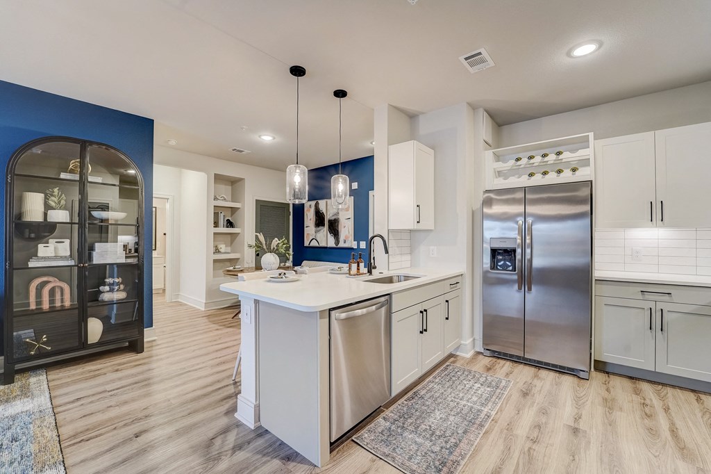 a kitchen with white cabinets and stainless steel appliances and a white counter top