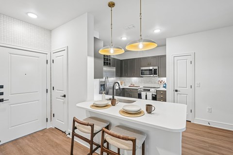 A kitchen with a white counter and a breakfast set on it.
