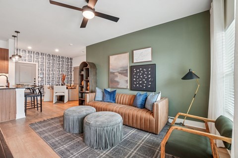 A living room with a brown couch and a ceiling fan.