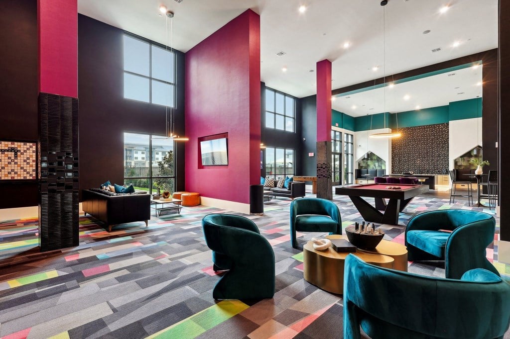 a lobby with chairs and tables and large windows