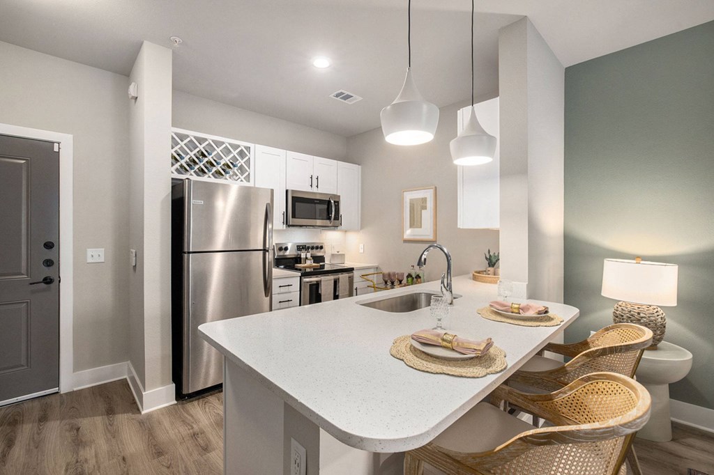 a kitchen with stainless steel appliances and a white counter top
