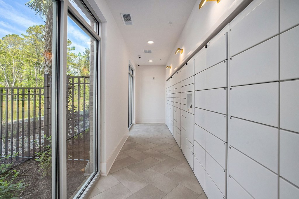 a long hallway with white cabinets and a sliding glass door