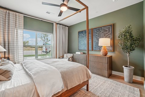 A bedroom with a large bed and a ceiling fan.