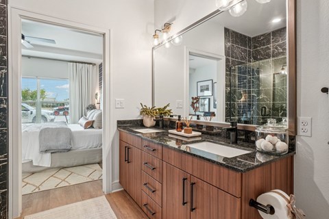 A bathroom with a marble countertop and a large mirror.
