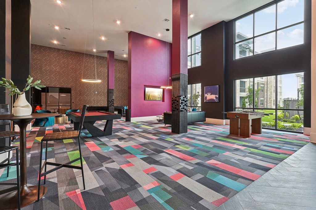 a lobby with a colorful rug and large windows