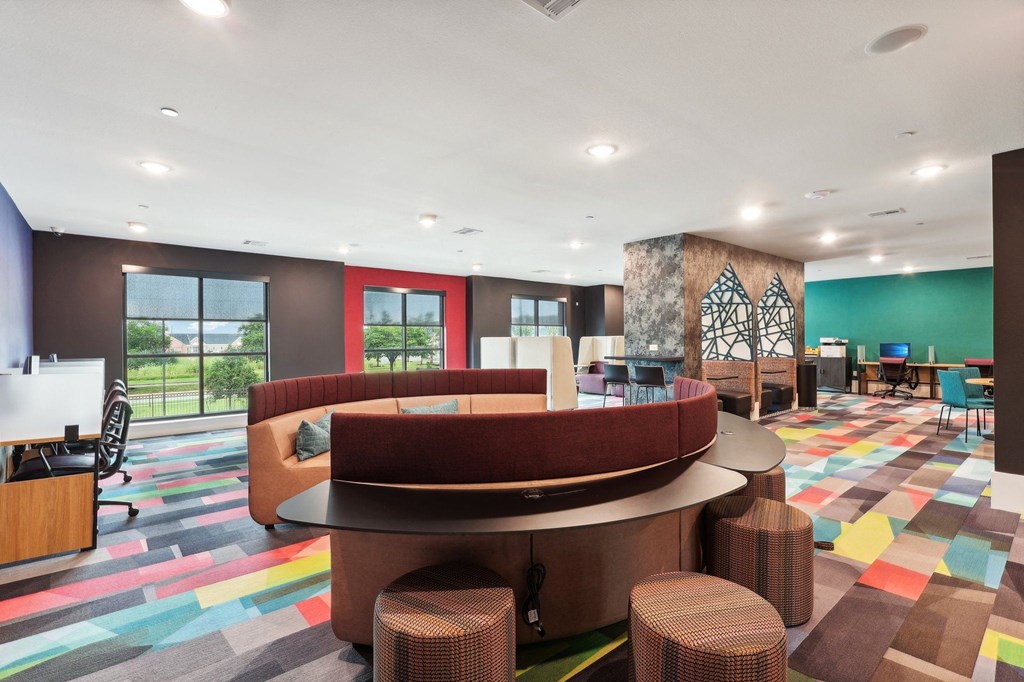 the lobby of a hotel with a colorful carpet and tables and chairs