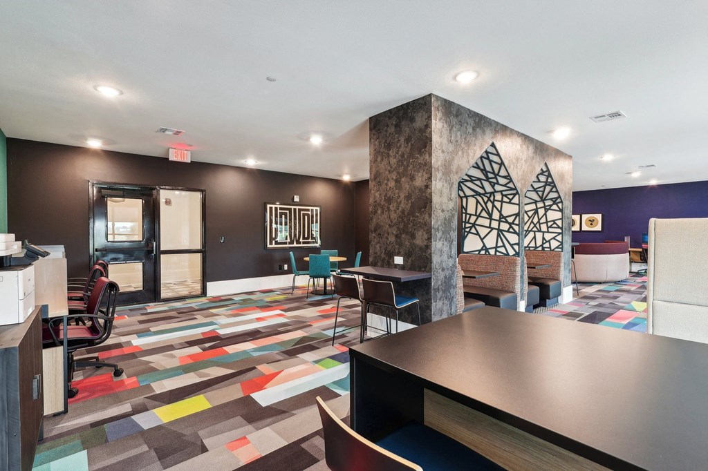 a spacious lobby with tables and chairs and a reception desk