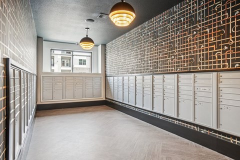 A hallway with a wall of lockers and a light hanging from the ceiling.