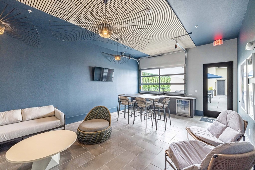 a lounge area with couches chairs and tables and a bar