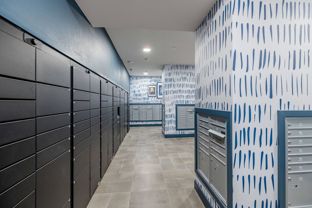 a hallway with lockers and a blue and white wallpaper