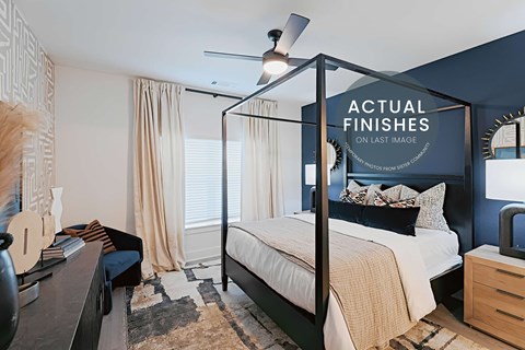 A bedroom with a four poster bed and a rug on the floor.