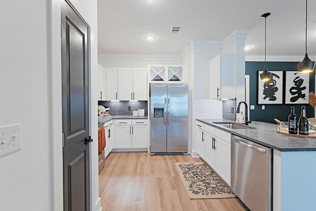 a kitchen with a stainless steel refrigerator and a sink