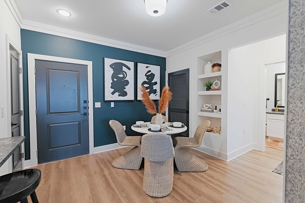 a dining room with a table and chairs and a blue wall