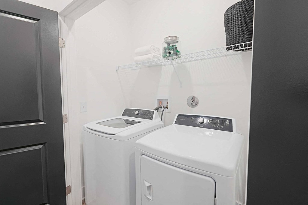 a white laundry room with two washes and a dryer