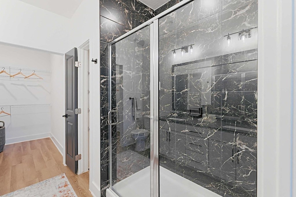 a black and white bathroom with a glass shower