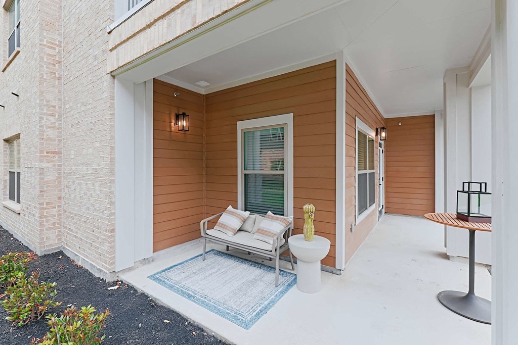a covered porch with a couch and a toilet