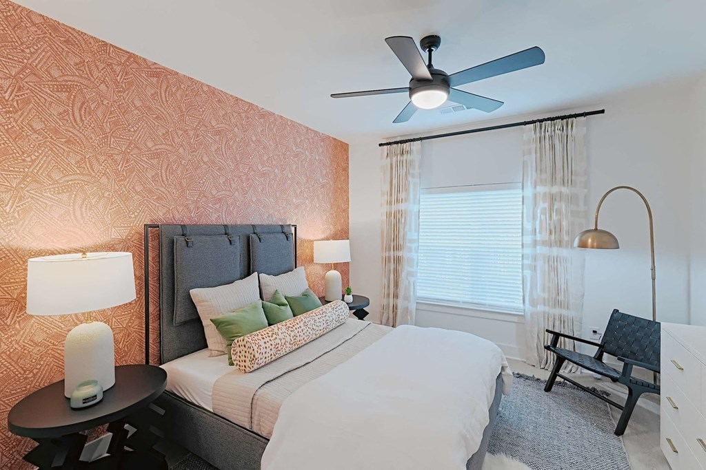 a bedroom with a large bed and a ceiling fan