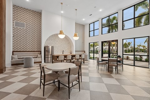 A dining room with a checkered floor and a table set for six.