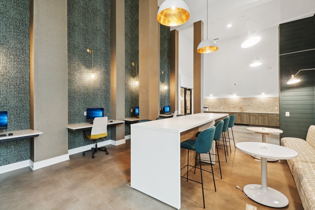 a large room with desks and chairs and a long counter with chairs and tables