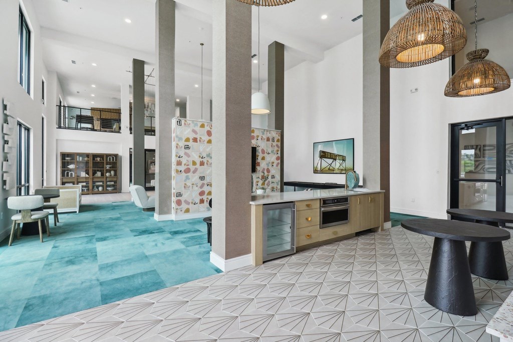 the lobby of a hotel with a reception desk and a blue rug
