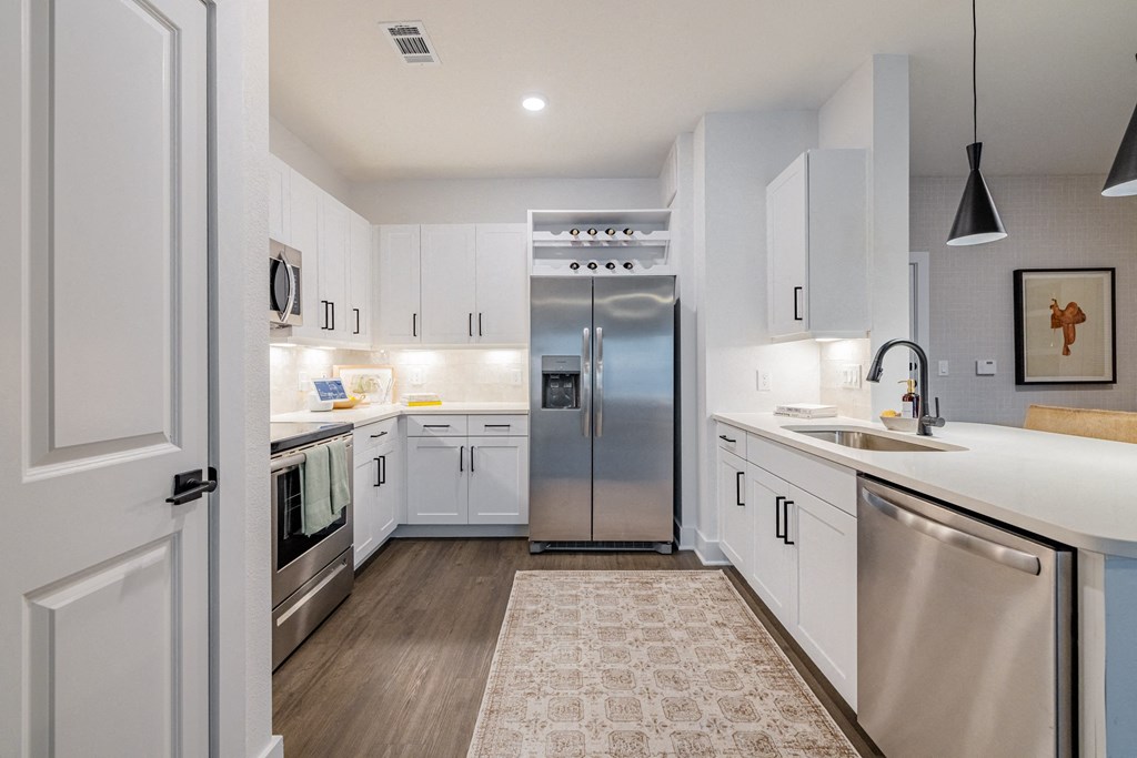 a renovated kitchen with stainless steel appliances and white cabinets