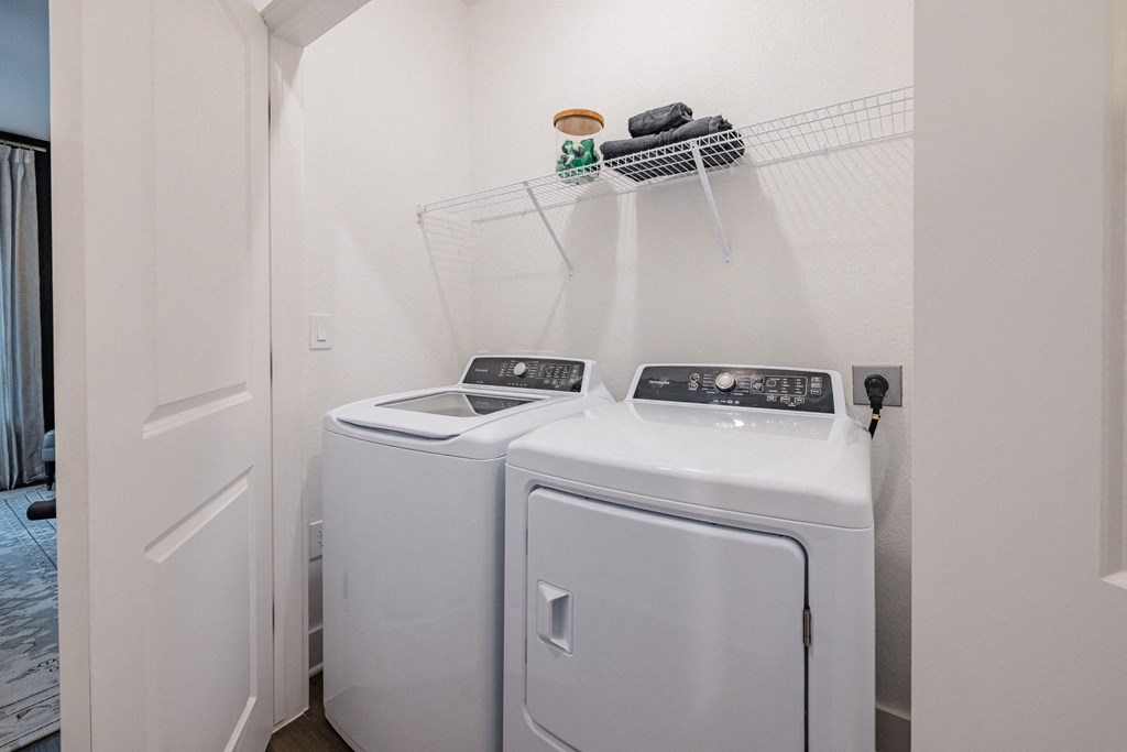 a washer and dryer in a laundry room with white walls and a door