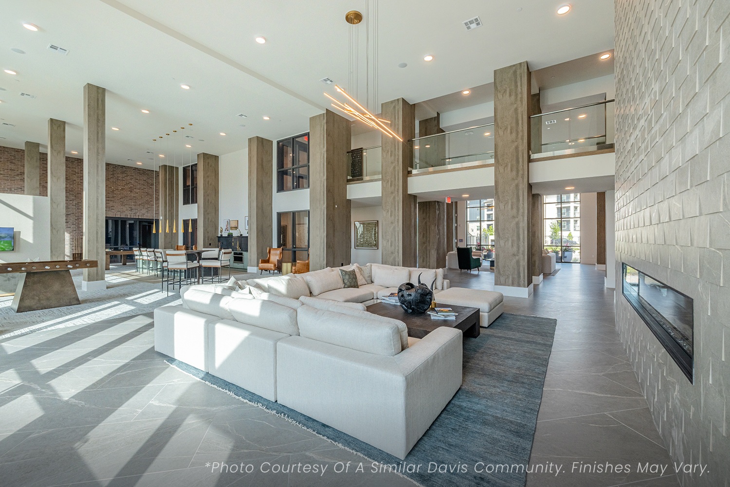 A spacious living room with a white couch and a fireplace.