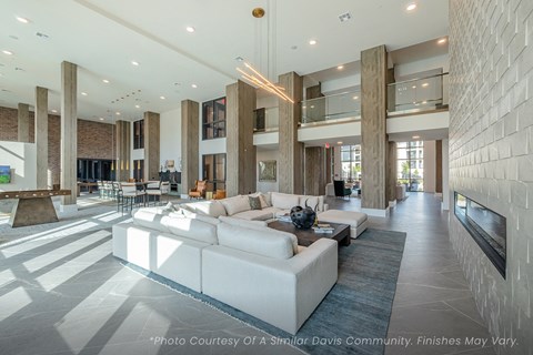 A spacious living room with a white couch and a fireplace.