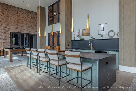 A kitchen with a long table and chairs.