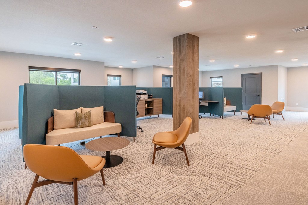 a lounge area with a couch and chairs and a desk