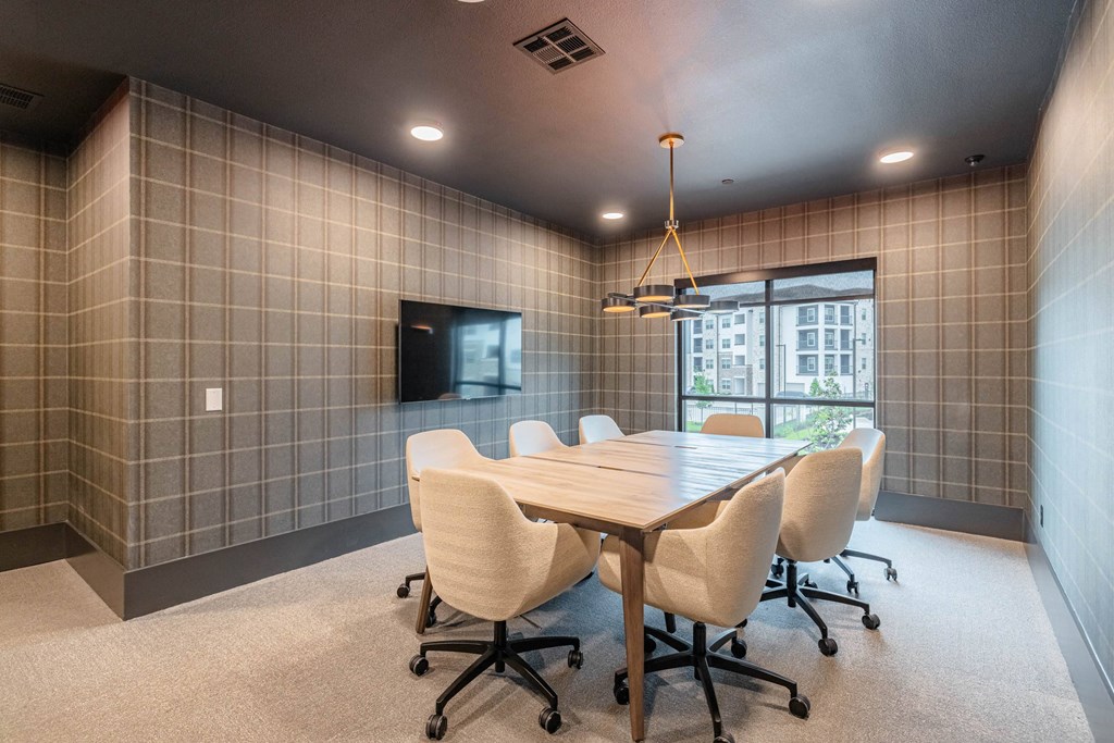 a conference room with a table and chairs and a tv
