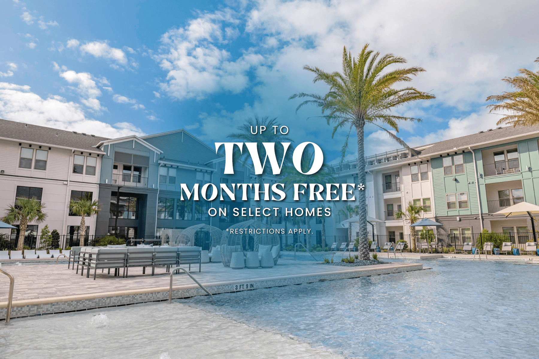 A pool in front of apartment buildings with a sign offering two months free on select homes.