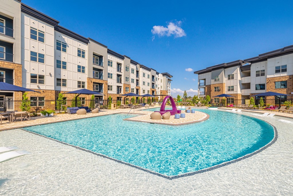 a swimming pool with an apartment building in the background