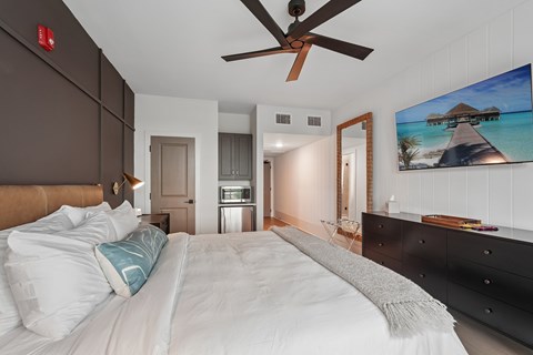 A bedroom with a large bed and a painting on the wall.