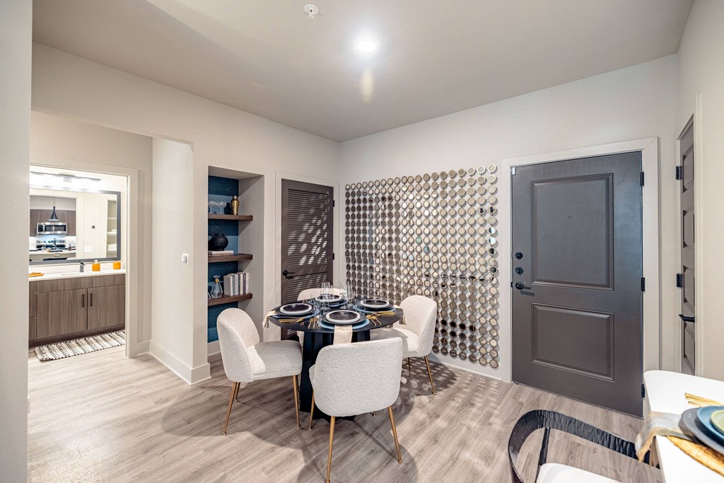 a dining room with a table and chairs and a door to a kitchen
