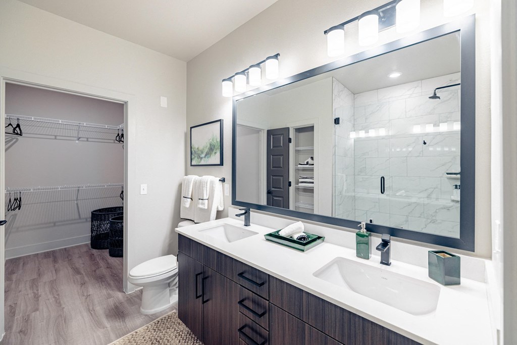 a bathroom with a large mirror and a sink and a toilet