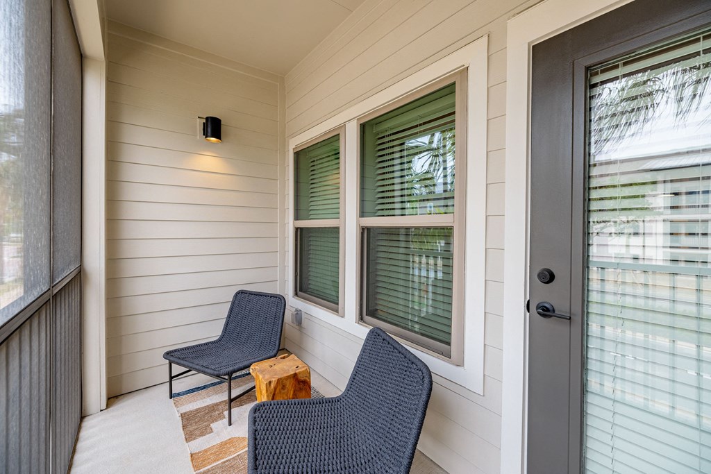 a porch with two chairs and a door