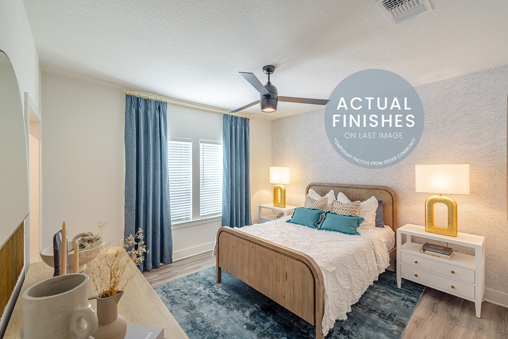 A bedroom with a bed, nightstand, and a ceiling fan.