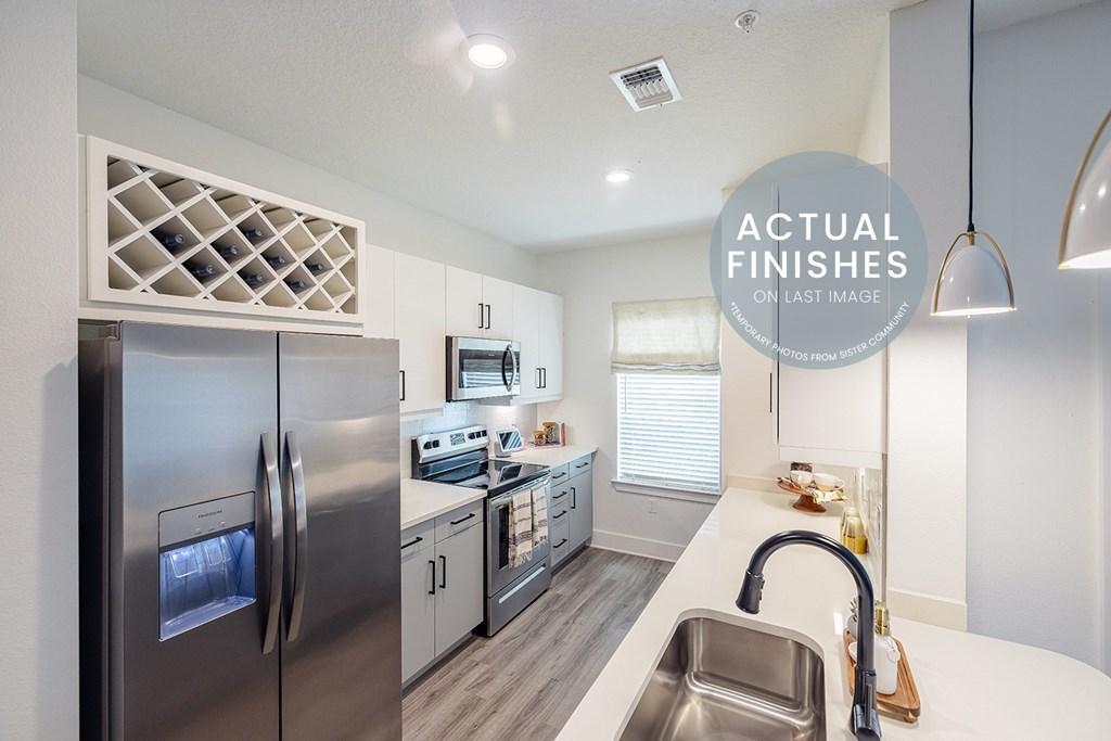 A modern kitchen with stainless steel appliances and a white countertop.