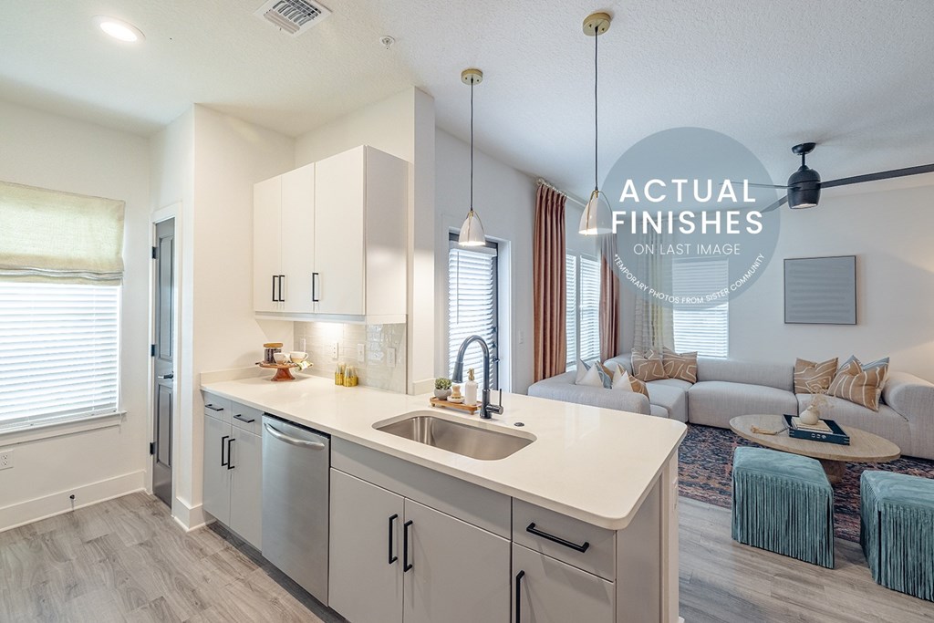 A kitchen with a sink, cabinets, and a window.