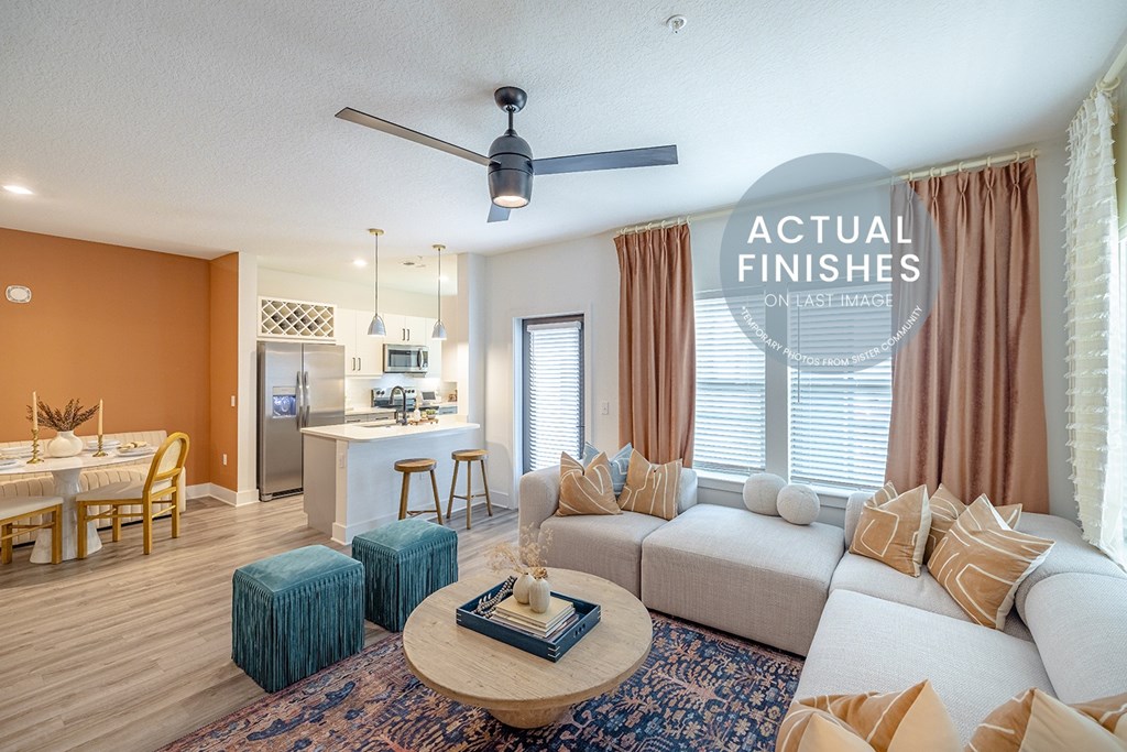 A living room with a white couch, a coffee table, and a dining table.