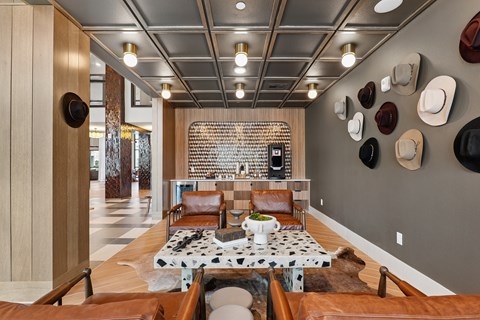 A modern living room with a cowhide rug and a black and white patterned coffee table.