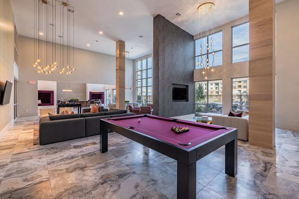 a pink pool table in a living room with couches