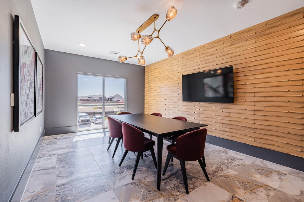 a dining room with a table and chairs and a tv on the wall